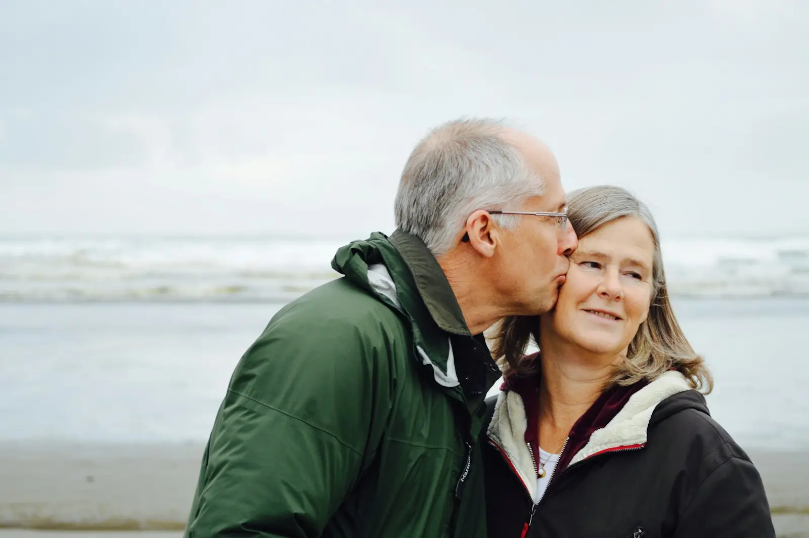 An older couple embracing by the sea