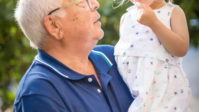 A grandfather holding his granddaughter
