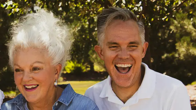 A retired couple laughing together outdoors